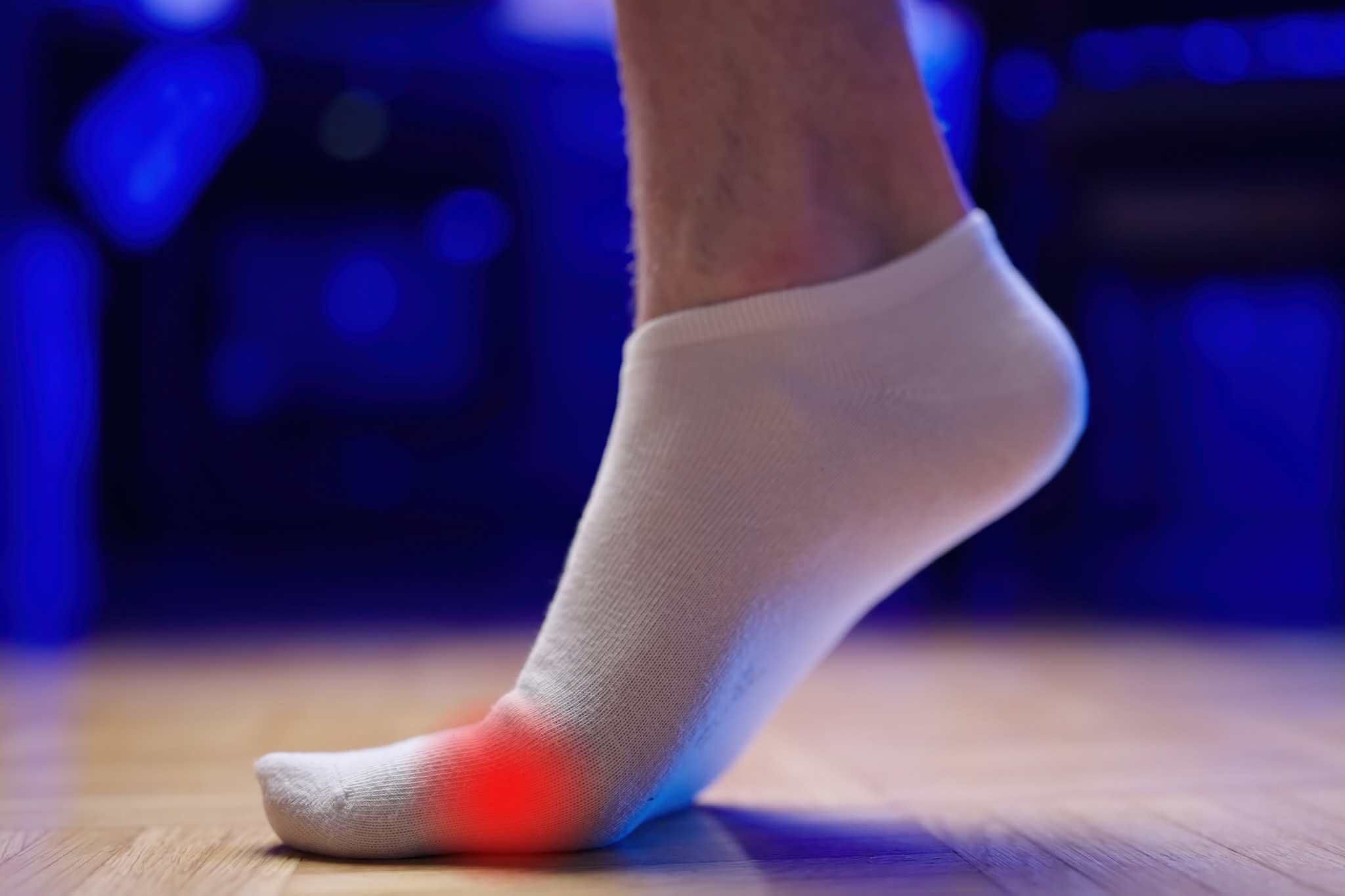 Stand on toes heel rise training flat feet arch side view wearing white socks. Turf toe pain