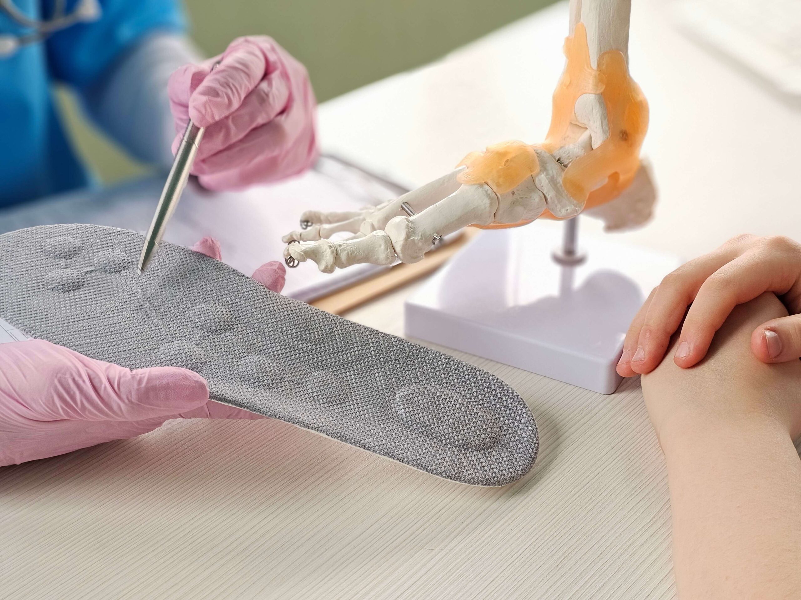 Doctor installing a custom orthopedic insole on a patient foot concept Doctor installing a custom orthopedic insole on a patient foot concept